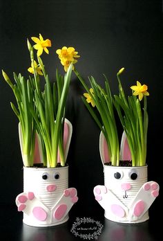 two tin cans with flowers in them and some bunny ears on the top one is made out of paper