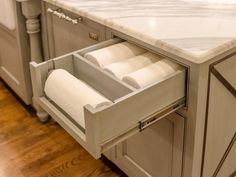 an open drawer in the middle of a kitchen counter with marble top and drawers on both sides