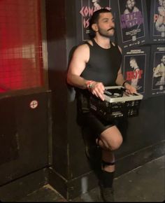 a man in black shirt and shorts holding a basket