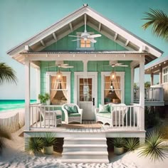 a house on the beach with two chairs and a ceiling fan in front of it