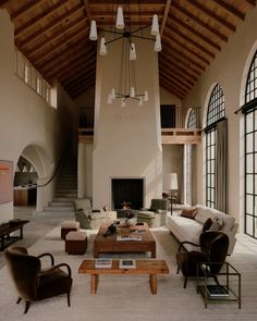 a living room filled with lots of furniture and a fire place in the middle of it