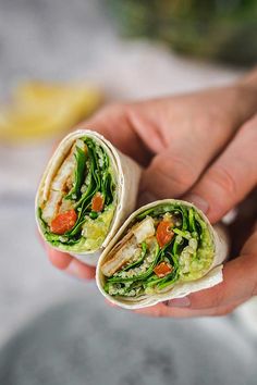 a person holding a burrito in their hand with vegetables and meat on it,