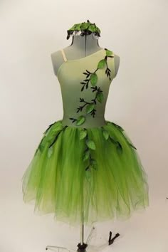 a green tutu skirt on a mannequin with leaves and vines painted on it