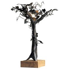 a metal tree sculpture on a wooden base