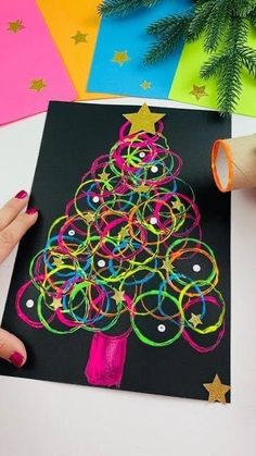 someone is making a christmas tree out of colored paper