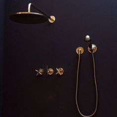 a shower head, hand held showerhead and brass faucet on a black background