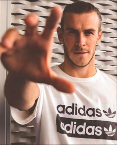 a man is making the vulcan sign with his hand while wearing a adidas t - shirt