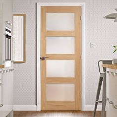 a kitchen with a wooden door and white walls