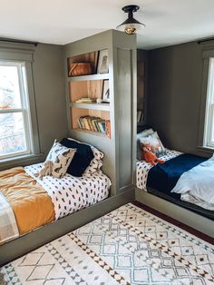 two twin beds in a bedroom with bookshelves on the wall and a rug on the floor