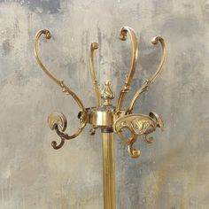 an ornately decorated gold candle holder stands against a wall