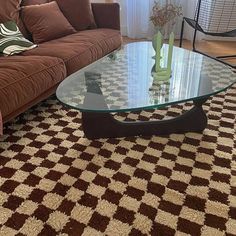 a living room with a couch, coffee table and rugs on the floor in front of a window