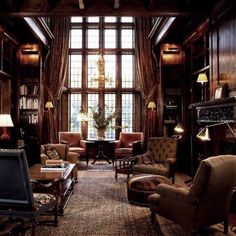 a living room filled with lots of furniture next to a large window covered in bookshelves