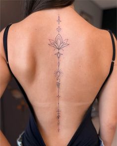 the back of a woman's neck with tattoos on her upper and lower back