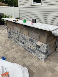 an outdoor bar is built into the side of a house with brick pavers around it