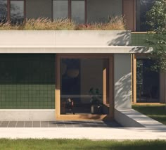 a building with green tiles and plants on the top floor, next to a sidewalk in front of it