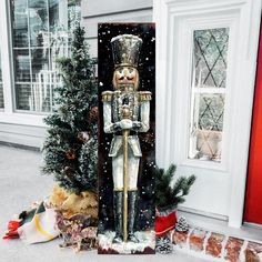 a christmas scene with a nutcracker statue in front of a house