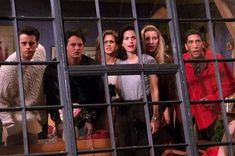 the cast of friends are looking out from behind bars in a jail cell window,