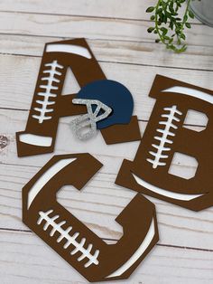 football cutouts with the letter b and ball on them sitting on a wooden table