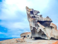 a large rock formation on top of a rocky outcropping next to the ocean