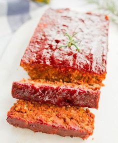 two slices of meatloaf on a white plate next to another piece of meatloaf