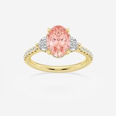 a yellow gold ring with an oval pink diamond and two white diamonds on the band