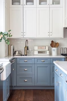 a kitchen with blue cabinets and white counter tops