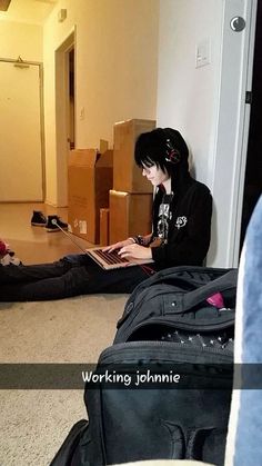 a person sitting on the floor using a laptop