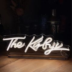 a neon sign sitting on top of a wooden table