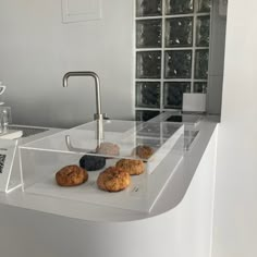 there are some cookies sitting on the counter in this modern kitchen, and it looks like they have been made out of acrylic