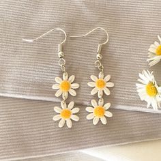 These adorable white daisy chain dangle earrings are the perfect unique summery accessory. The polymer clay they are made from is very lightweight and comfortable, and each pair is slightly different due to the nature of handmade products. White Daisy-shaped Jewelry For Spring, White Daisy-shaped Spring Jewelry, White Dangle Flower Earrings For Spring, Trendy White Earrings With Flower Charm, Trendy White Daisy Shaped Jewelry, Trendy White Daisy-shaped Jewelry, Minimalist White Jewelry For Spring, Dainty White Dangle Flower Earrings, Dainty White Earrings For Spring