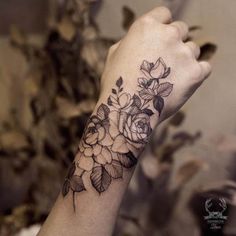 a woman's arm with flowers on it and the word tattoo written in black ink