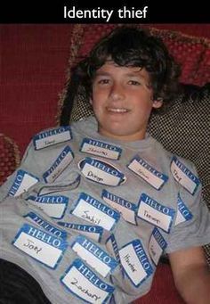 a young boy is sitting on a couch with his name tags in front of him