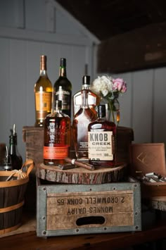 an old wooden crate filled with bottles of liquor on top of a table next to a basket