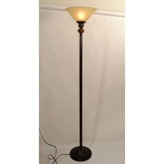 a lamp that is on top of a white table next to a black pole with a light in it