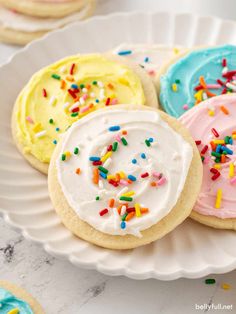 several decorated cookies on a plate with sprinkles