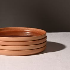 a stack of clay bowls sitting on top of a table