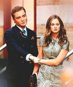 a man and woman standing next to each other in front of an escalator