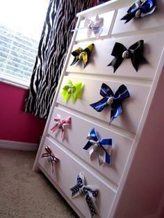 a white dresser with many different colored bows on it