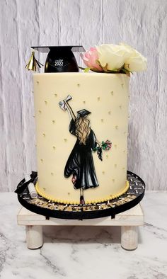 a cake decorated with an image of a graduate holding a rose and a bottle of wine