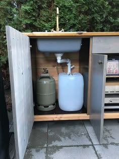 an outdoor sink with a water tank in it