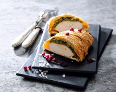 a sandwich cut in half sitting on top of a cutting board next to a knife and fork