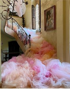 a staircase with pink and yellow tulle skirted dress on it's floor