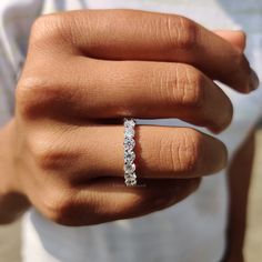 a woman's hand with a diamond ring on her left hand and the other hand holding