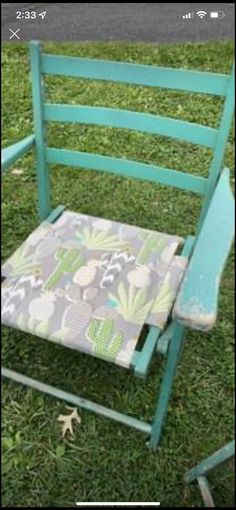 a green chair sitting in the grass with a cushion on it's seat cover