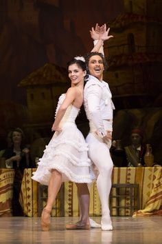 two ballerinas in white tutus are posing for the camera with their arms around each other