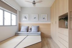 a bed sitting in the middle of a bedroom next to a wooden cabinet and window