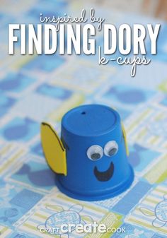 a blue cup that is sitting on top of a table cloth with the words finding dory ke - cups