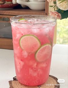 a pink drink with lime slices on the rim