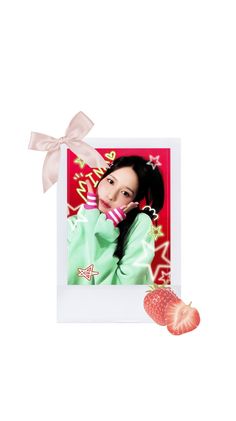 a strawberry with a ribbon around it sitting next to a photo on a white background