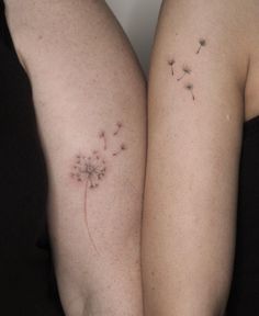 two women with tattoos on their arms and one has a dandelion tattoo on her arm